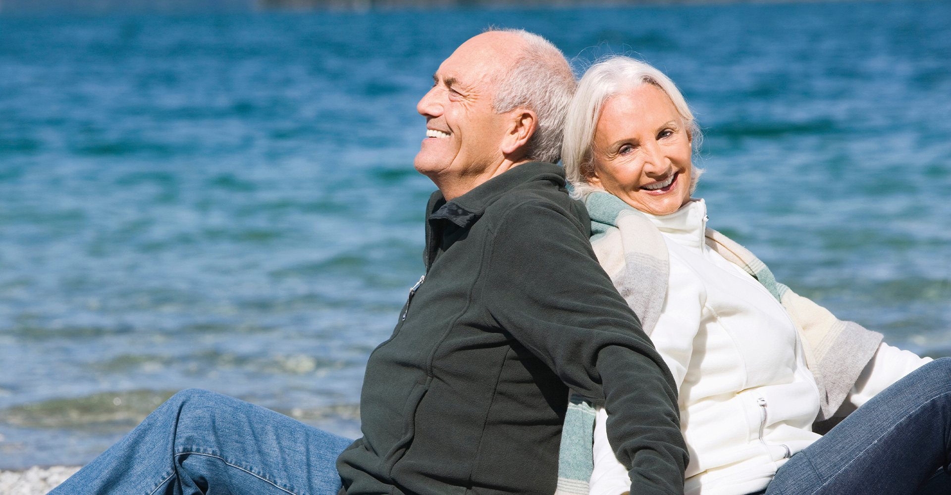 Ein älteres Paar, das am Strand sitzt.